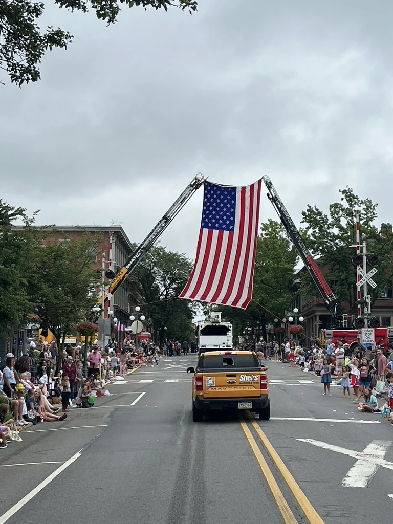 American flag displayed between ladder trucks at a completed paving project in Pennsylvania