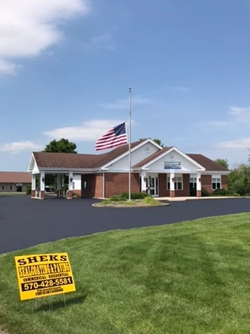 Commercial building with newly paved asphalt entrance and parking area
