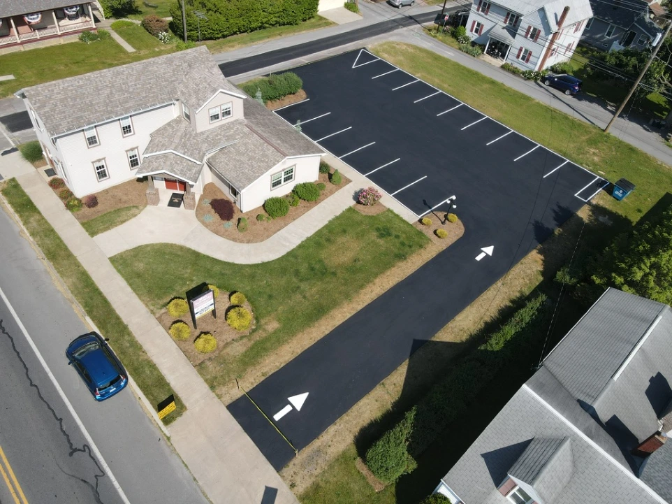 Aerial view of a completed commercial property with newly paved parking lots, walkways, and landscaped surroundings.