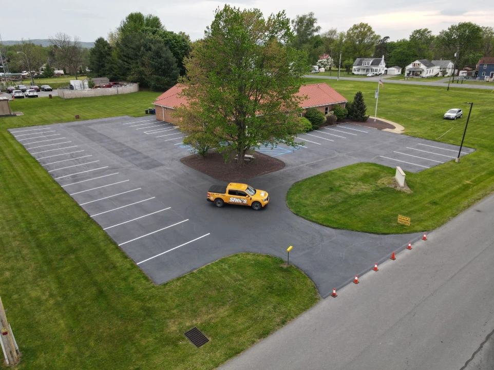 Completed commercial parking lot paving project with new asphalt, curbing, and landscaped islands.