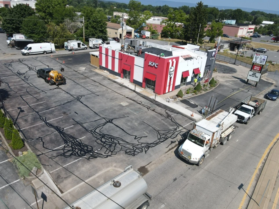Commercial asphalt paving project featuring heavy equipment and newly installed pavement.