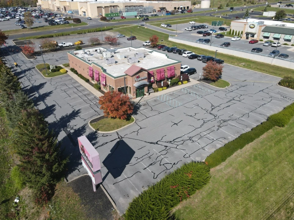 Freshly paved commercial parking lot with clearly marked parking spaces and smooth asphalt surface.