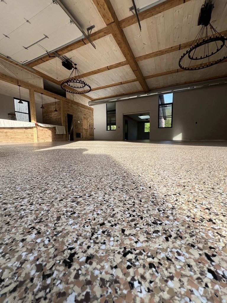 Durable epoxy flooring installation inside a commercial facility with a decorative stone finish.